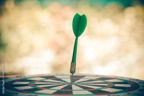 green dart on dart board with clor background photo