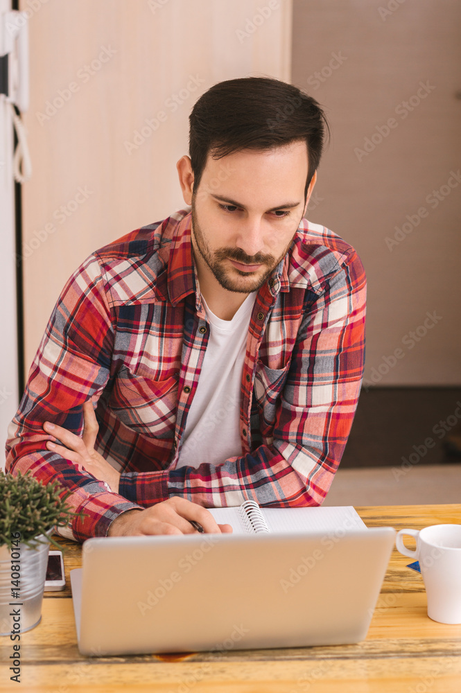 Young happy designer working on laptop from home Young happy designer working on laptop from home