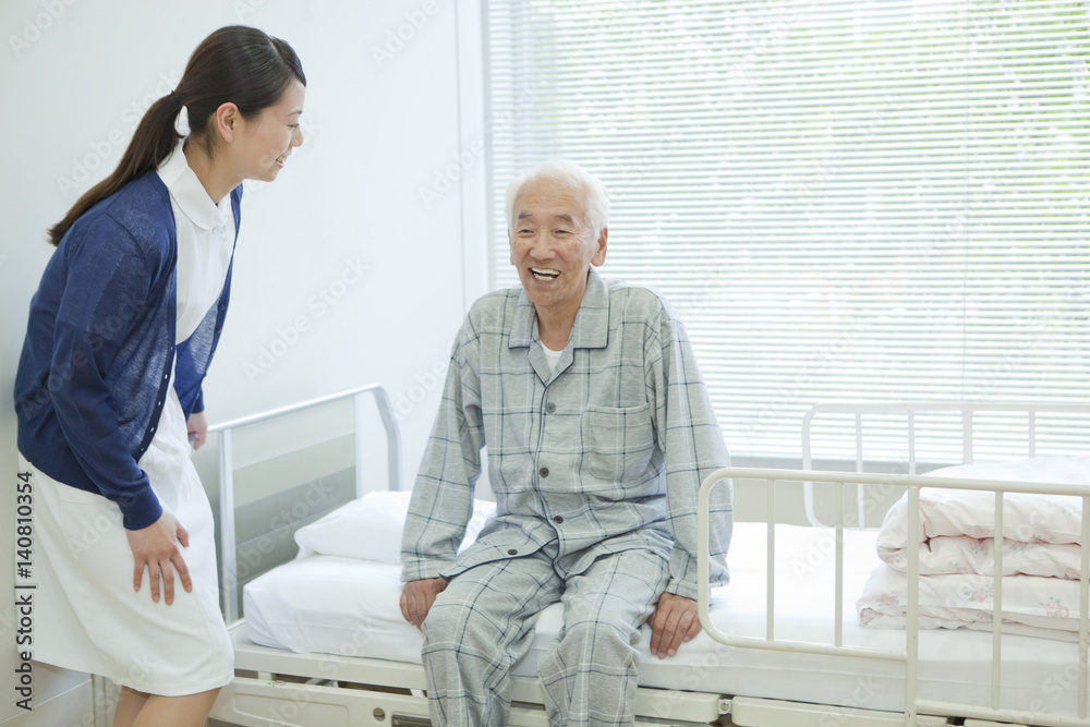 Senior man sitting on hospital bed, Kanagawa Prefecture, Honshu, Japan Senior man sitting on hospital bed, Kanagawa Prefecture, Honshu, Japan