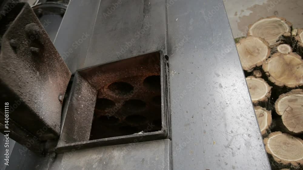 The man opens and closes the door of a wood-fired boiler
The man opens and closes the door of a wood-fired boiler