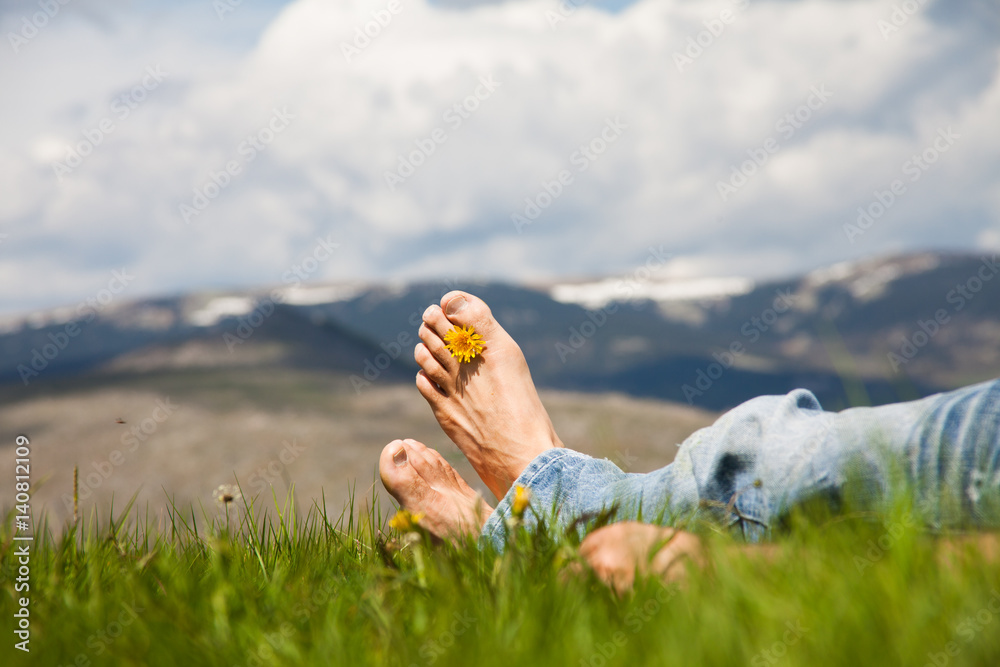 pieds nus d'homme dans l'herbe avec une fleur dans les orteils Stock Photo  | Adobe Stock