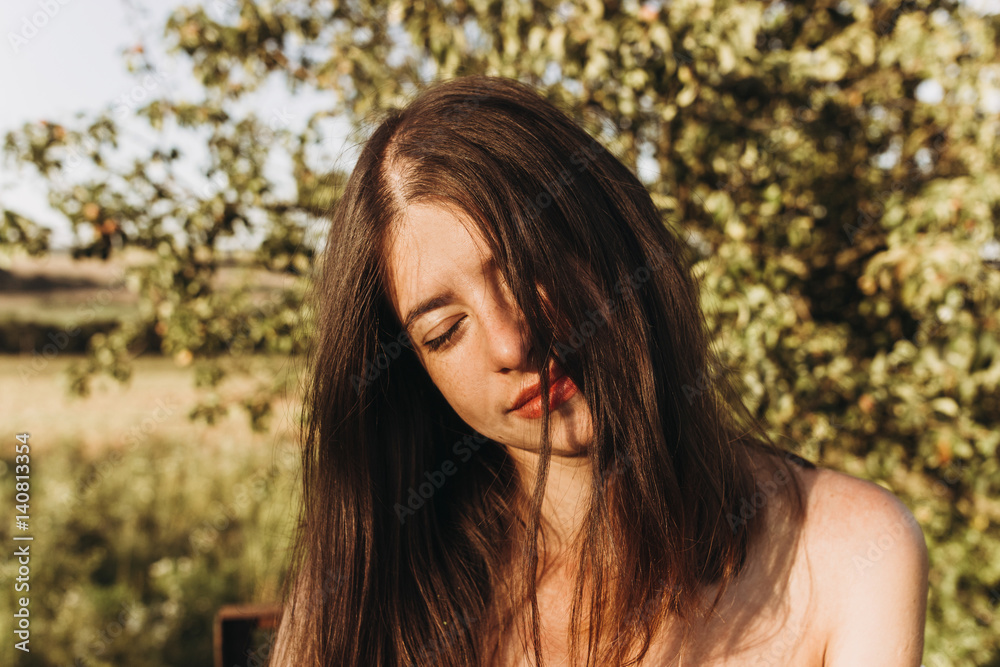 sensual woman relaxing in evening under sunlight in summer field. stylish hipster girl traveling. tender sensual portrait in sunshine. sensual woman relaxing in evening under sunlight in summer field. stylish hipster girl traveling. tender sensual portrait in sunshine.