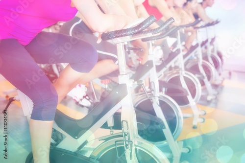 Composite image of spin class working out in a row