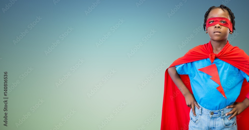Boy in superhero costume standing with his hands on his waist