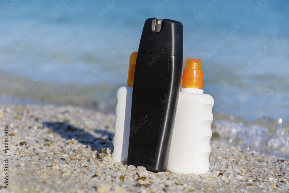 sunscreen bottles on the beach.summer sunbath - suntan oil sunscreen bottles on the beach.summer sunbath - suntan oil