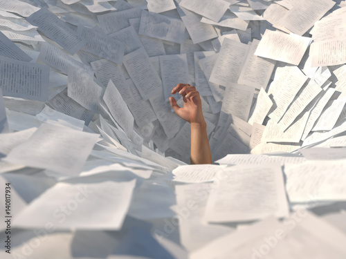 hand drowning in paper sheets