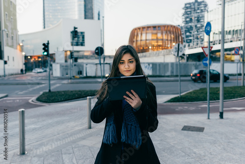 Young beautiful eastern woman outdoor in the city evening using tablet hand hold - technology, social network, communication concept © Eugenio Marongiu