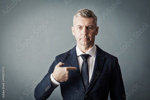 Businessman is pointing at himself