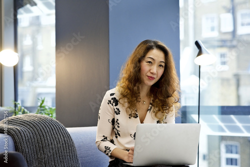 Asian businesswoman in an office with mobile device