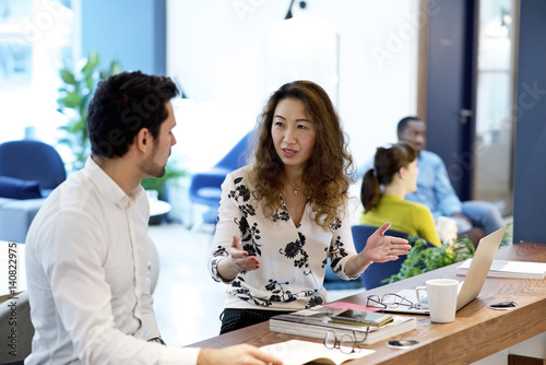 Woman and man talking in office
