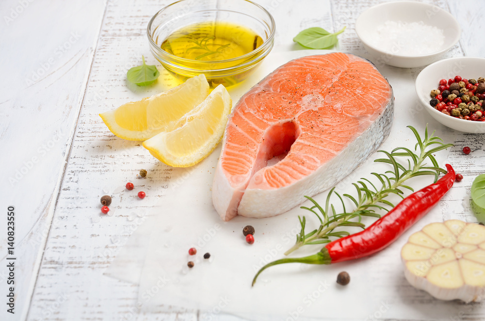 Fresh raw salmon steak with lemon, olive oil and spices on rustic wooden background. Ingredients for making healthy dinner. Healthy diet concept. Selective focus. Fresh raw salmon steak with lemon, olive oil and spices on rustic wooden background. Ingredients for making healthy dinner. Healthy diet concept. Selective focus.