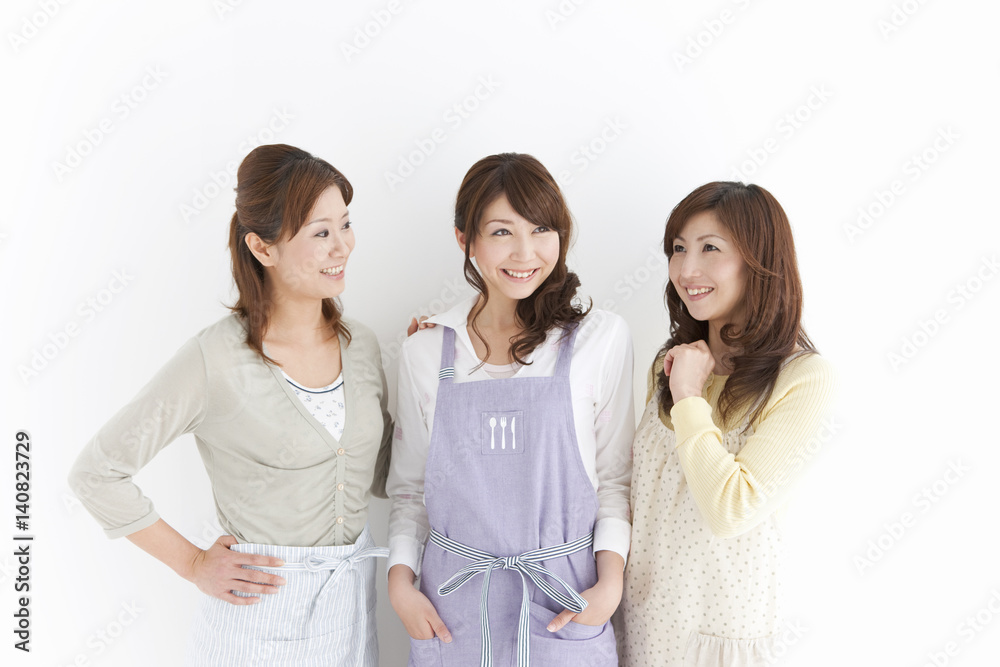 Three women smiling wearing aprons Three women smiling wearing aprons