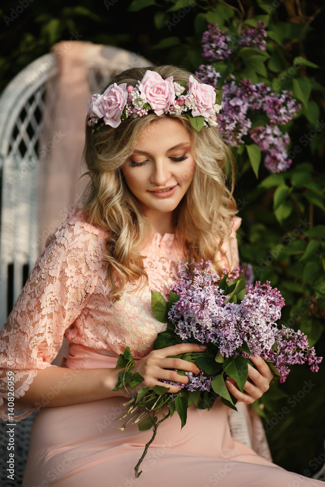 Beautiful woman with lilac bunch and wreath of flowers in spring garden, portrait og young pregnant mother Beautiful woman with lilac bunch and wreath of flowers in spring garden, portrait og young pregnant mother