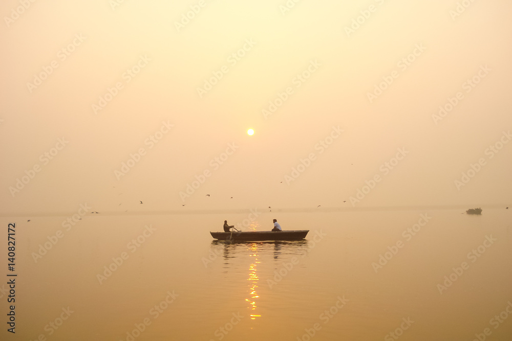 A single angler enjoys fishing from a boat on a beautiful morning.