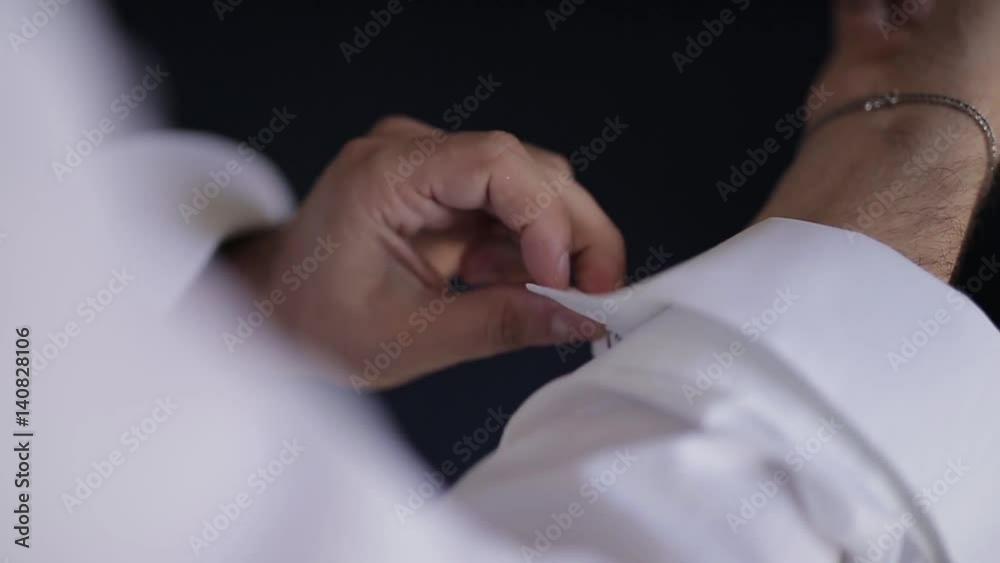Wedding, groom putting on his cufflinks Wedding, groom putting on his cufflinks