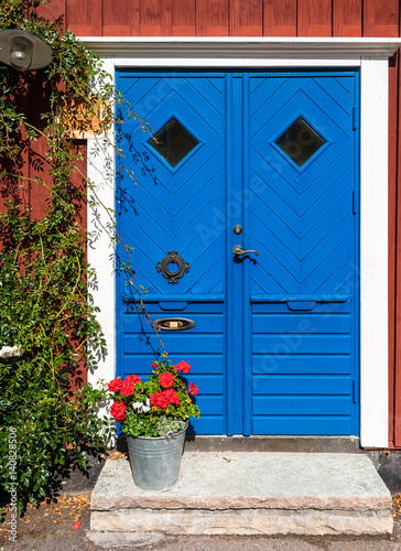 Wooden blue door and bucket with flowers, Kalmar, Sweden.