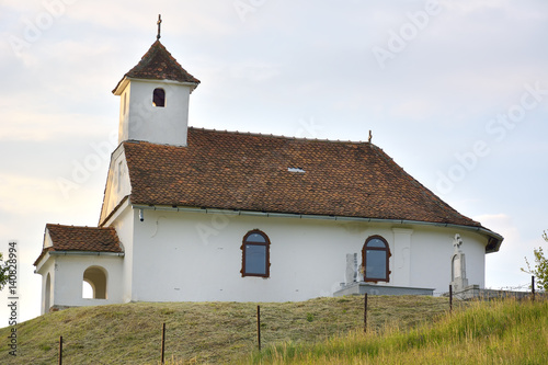 Small church on top of a green hill