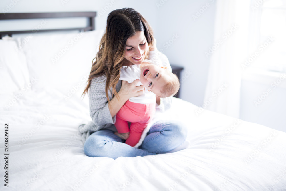 Mother and baby child on a white bed. Mother and baby child on a white bed.
