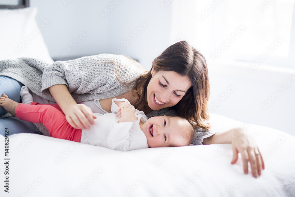 Mother and baby child on a white bed. Mother and baby child on a white bed.