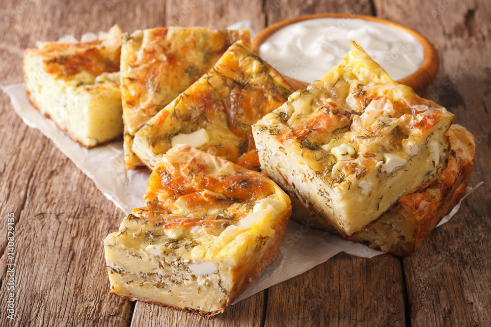 Traditional Serbian Gibanica with cheese, eggs and greens close-up and yogurt. horizontal Traditional Serbian Gibanica with cheese, eggs and greens close-up and yogurt. horizontal