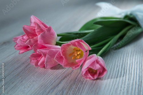 Fototapeta Naklejka Na Ścianę i Meble -  A bouquet of tulips lies on a wooden table.
