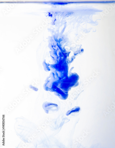 Blue Watercolor drops into the water on a white background.