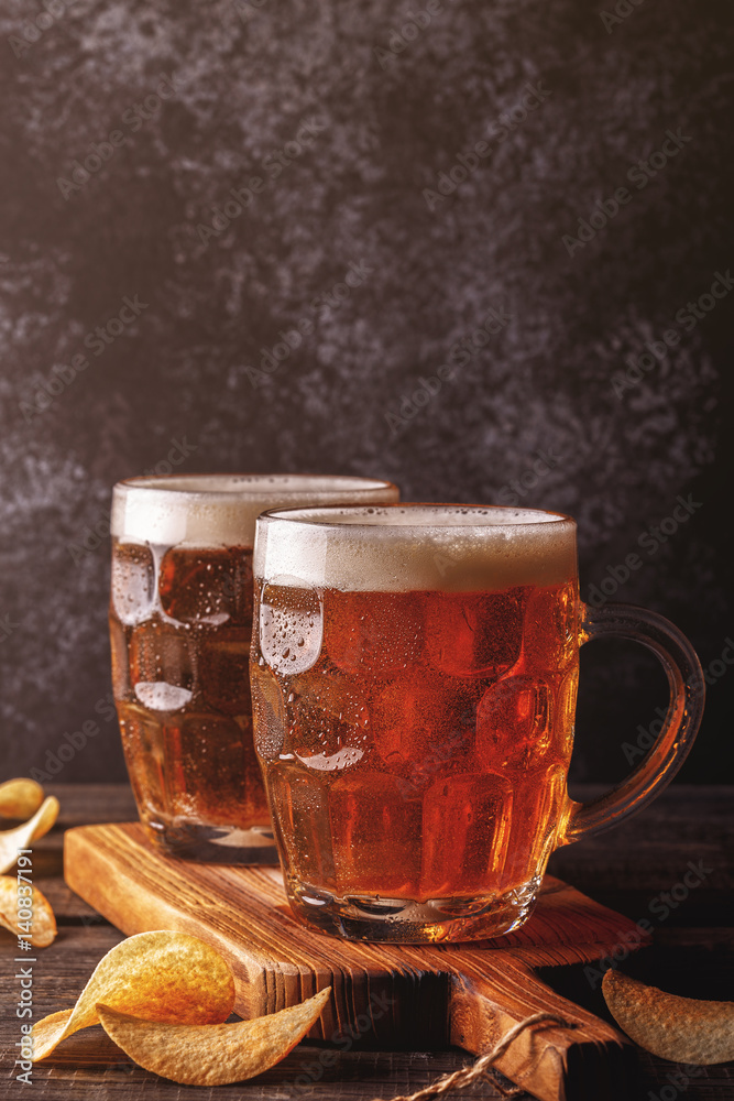 Cold beer in glass with chips on a dark background. Cold beer in glass with chips on a dark background.