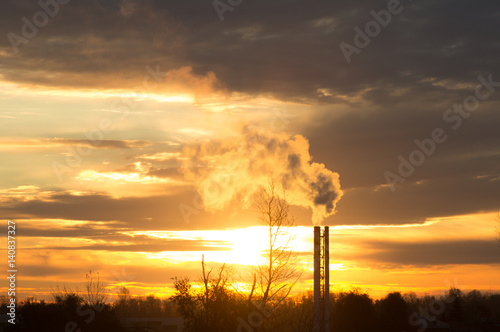 Smoke from the boiler pipes at sunset.
