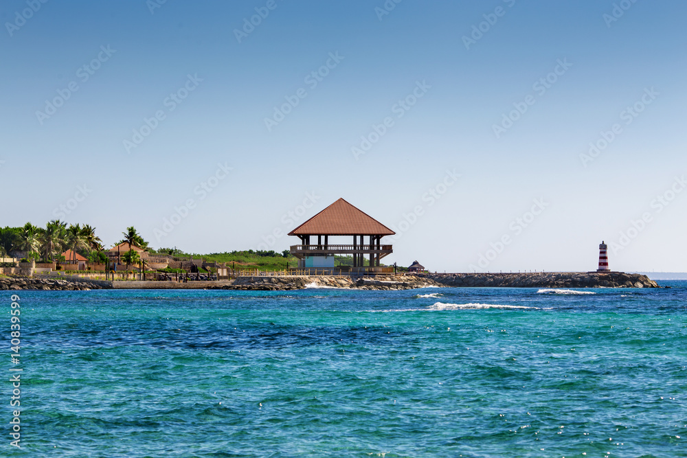 wooden house Bungalow and a lighthouse on the seashore
