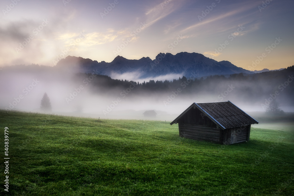 Geroldsee forest with beautiful foggy sunrise over mountain peaks, Bavarian Alps, Bavaria, Germany.