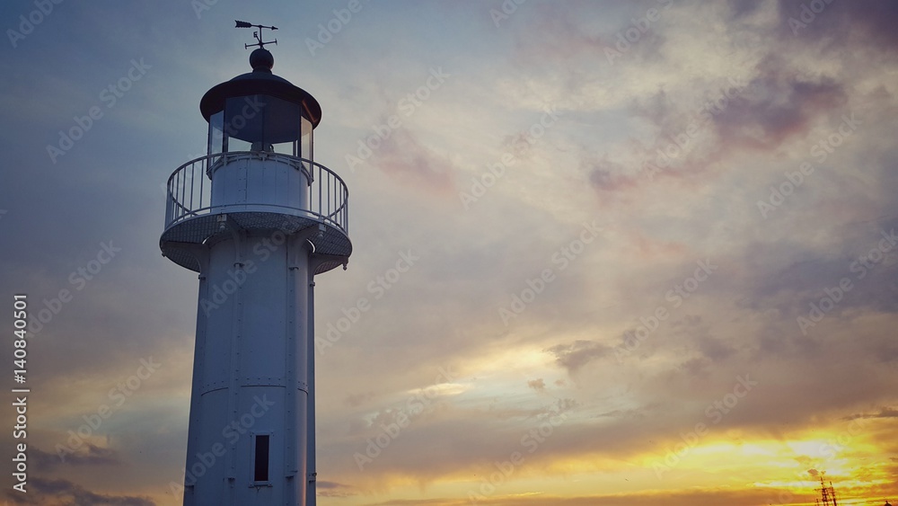 Beautiful sea sunrise. Lighthouse againt the sky.