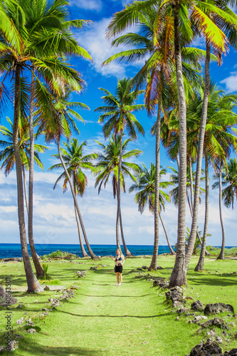 Young girl traveller on the green road with palm trees. Caribbean vacation. Samana, Dominican Republic