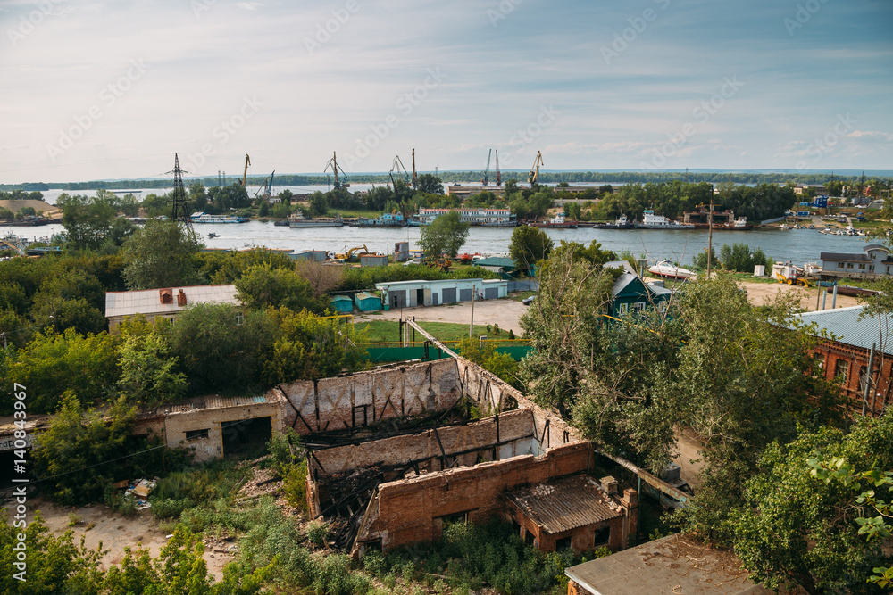 Industrial zone on the banks of the Volga, cranes, barges