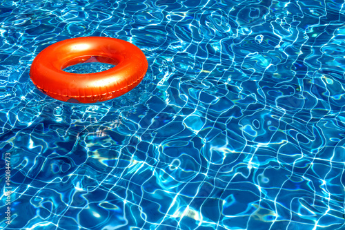 Fotografija Orange pool float, ring floating in a refreshing blue swimming pool