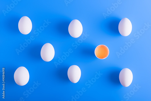 White eggs in a rows on blue background © Yulia Mladich