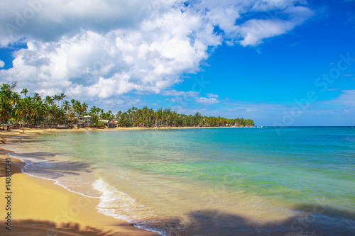 Ideal vacation. Perfect beach in Dominican Republic. Blue sea, hight palm trees and blue sky