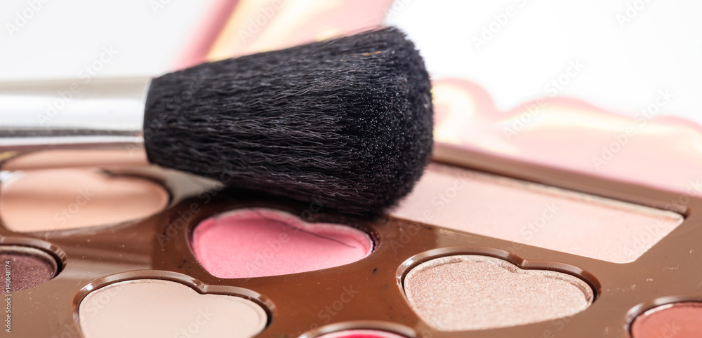 Makeup brush on an eye shadows palette Makeup brush on an eye shadows palette