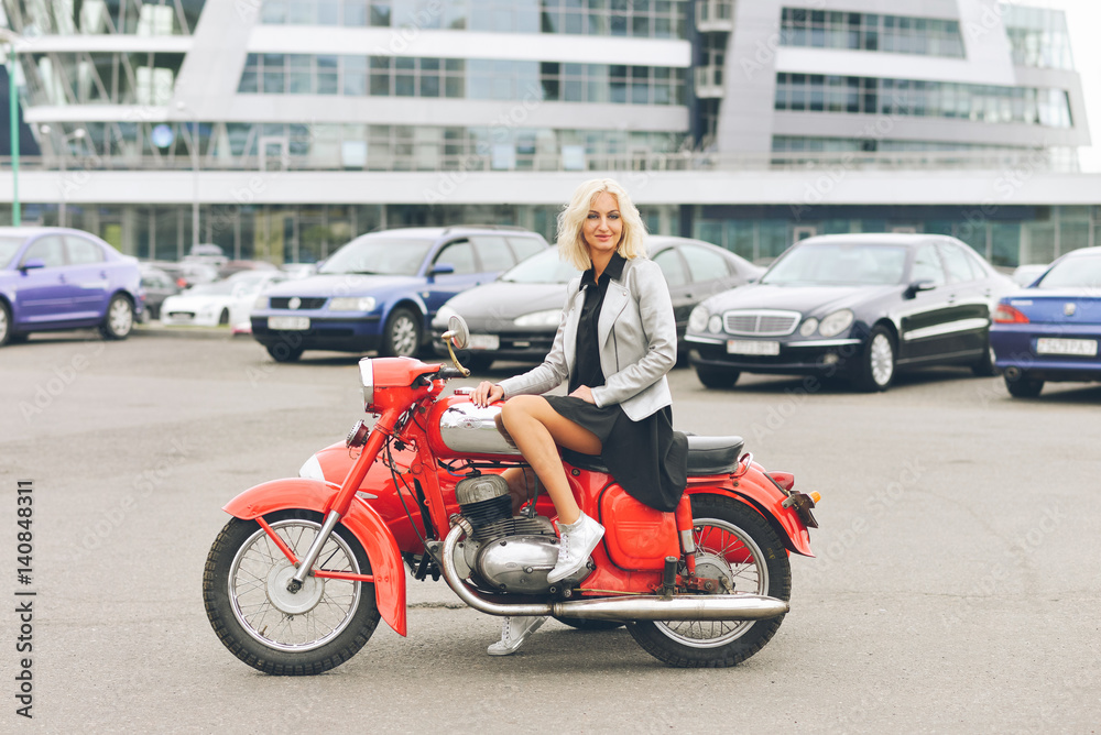 Blonde girl on a red motorcycle