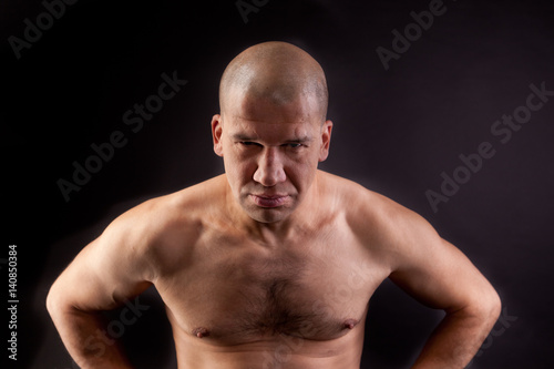 Muscular young man shirtless on a black background © annatronova