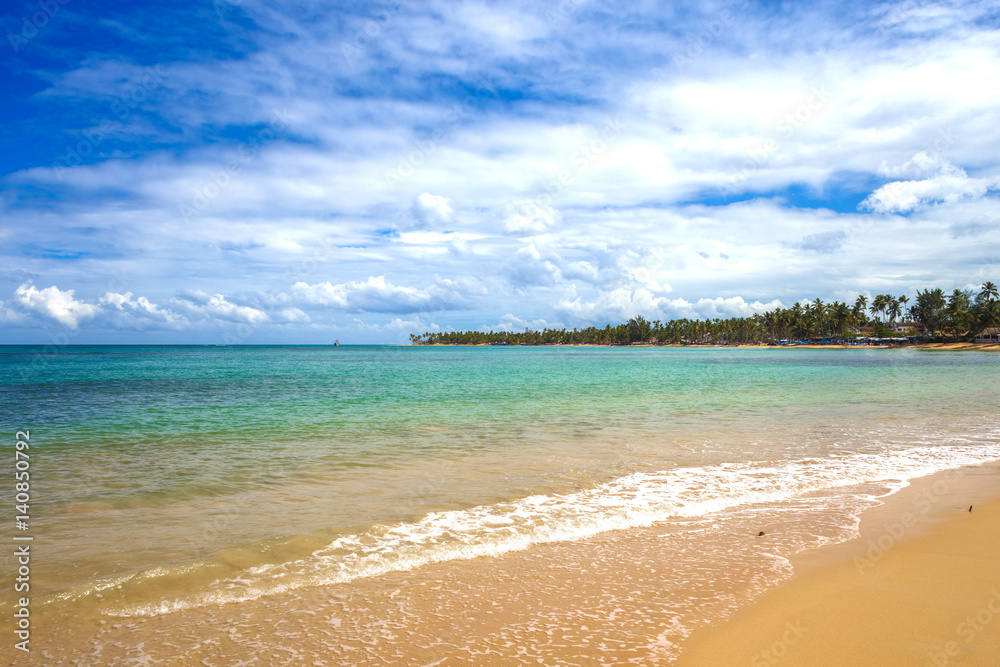 sea surf on the beach. Sand, sea, blue sky and white clouds