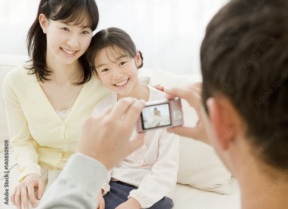 Father taking a photograph of mother and daughter Father taking a photograph of mother and daughter