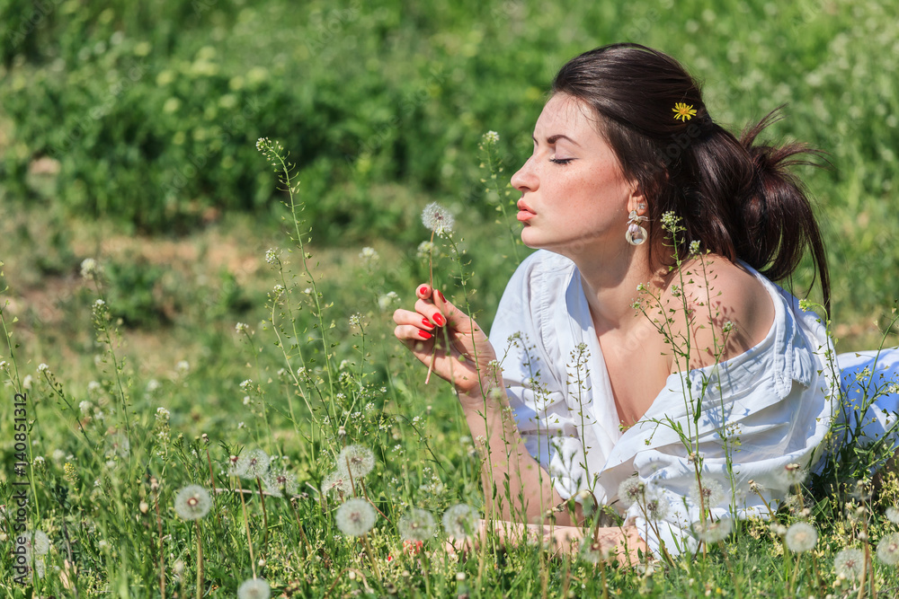 Girl with dandelion lying on green grass Girl with dandelion lying on green grass