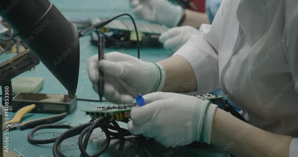 Workers marking circuit board closeup Workers marking circuit board closeup