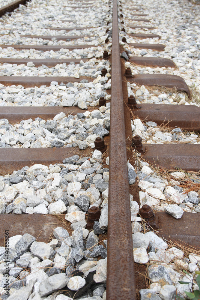 Railway track, metal railway sleepers and ballast. StockFoto Adobe Stock