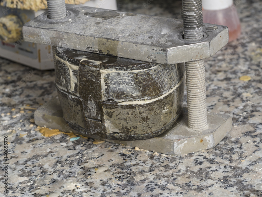 Dental technician is working with a dental flask of a complete upper on cast