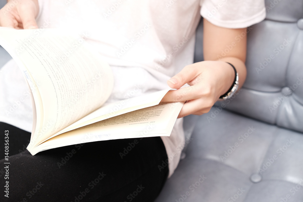 Girl sitting on sofa and reading book Girl sitting on sofa and reading book