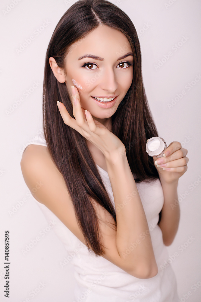 Beautiful Young Woman with Clean Fresh Skin touch her face . Facial treatment . Cosmetology , beauty and spa .