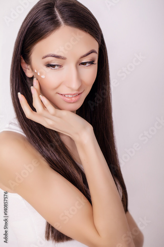 Concept skin care. A young healthy woman with cosmetic cream on a clean fresh face. Beauty and health. Facial Beauty Treatment Concept. High Resolution Image.