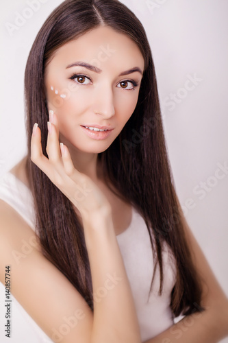 Beautiful woman face close up studio on pink. Picture of beautiful woman beautiful woman in spa salon. Clean Fresh Skin touch own face. Facial treatment . Cosmetology, beauty and spa