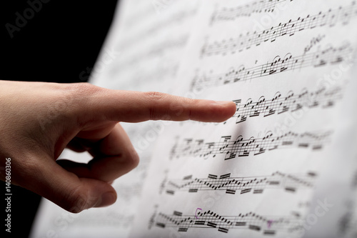 finger pointing to music score